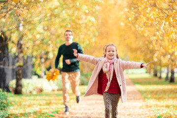 Naklejka na ściany i meble Family of dad and kid on beautiful autumn day in the park