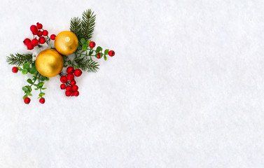 Christmas decoration. Twigs christmas tree, christmas yellow balls and red berries on snow with space for text. Top view, flat lay