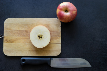 Slice apple on black background, knife on black,