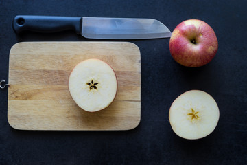 Slice apple on black background, knife on black,