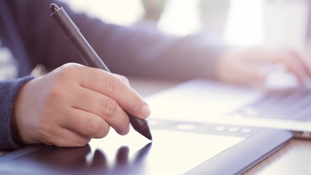 close up shot of a female designer hand using a drawing tablet