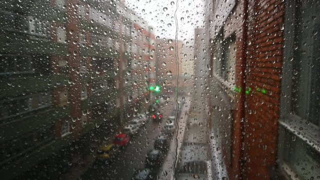 LLoviendo en el exterior visto a traves de cristal de ventana con gotas de lluvia
