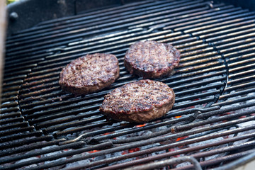 Hamburgers are cooking on the grill