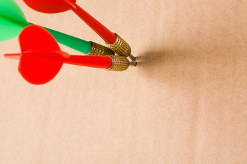 Three darts on yellow cardboard