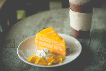 layer cake with orange flavor and ice coffee mocha in outdoor cafe