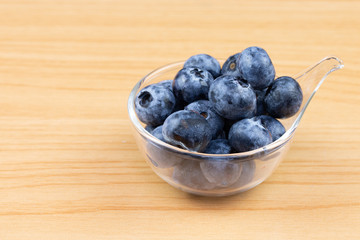 blueberry in cup on wood table background