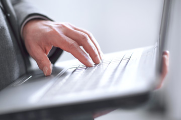 close up.hand businessman on laptop keyboard.isolated on blurred