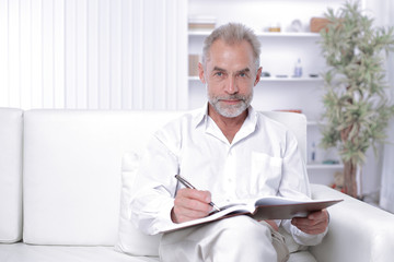 senior businessman making a note in the workbook