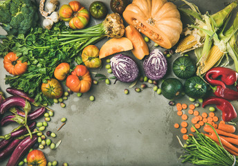 Healthy vegetarian seasonal Fall food cooking background. Flat-lay of Autumn vegetables and herb over grey concrete background, top view, copy space. Clean eating, alkaline diet food