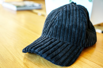 Fototapeta na wymiar Fur black cap placed on wooden desk.