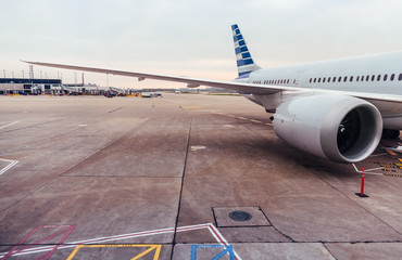 View of airplane wing and engine on tarmac at airport