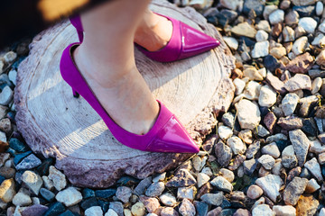 Elegant purple woman shoes on female legs 