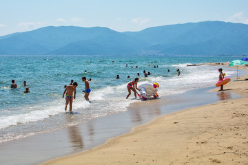 Fototapeta premium Asprovalta, Greece - August 20, 2018: Asprovalta and New Vrasna resort, Asprovalta beach. Sea view to Asprovalta at the foot of the green hills.