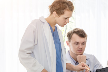 Medical professionals caucasian man holding xray and conversation about patient with young doctor woman.Stressed and worry doctor gives bad news.Close up and copy space.