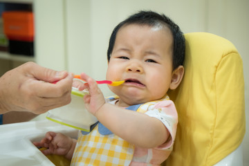 Asian baby girl refusing to eat food.tradition weaning