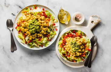 Healthy vegan salad with fresh vegetables, sprouts, avocados and chickpeas in mango juice. Raw food for a healthy family