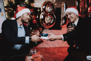 Businessmen in Red Caps in Office on New Year Eve.