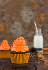 Halloween homemade cupcakes with milk bottle at rusty orange background. Space for text.