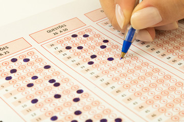 Education and concept. Student. Female hand with pen filling multiple choice test. Optical form of...