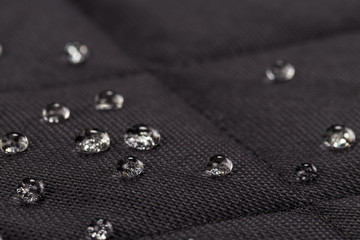 Water drops on waterproof black fabric