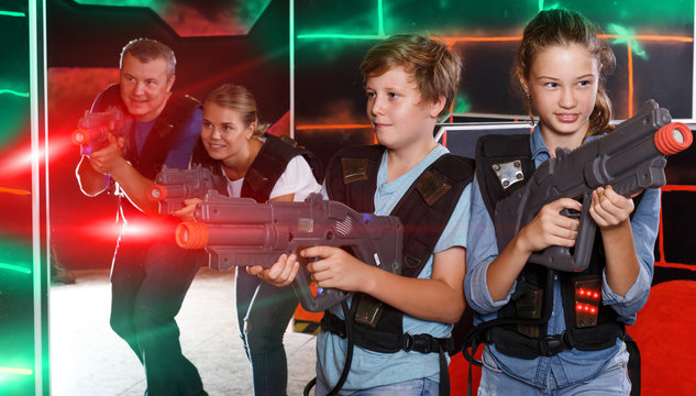 Smiling kids and  parents with laser guns and playing together l