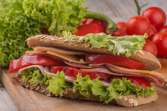 Sandwich with salami, cheese and salad in integral roll.Close up shoot