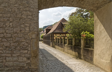 A stone gate - a view of historic buildings.