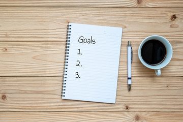 notebook, pen and black coffee on wooden background. Business and relaxing concepts