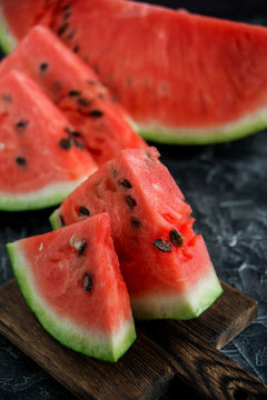 Slices of fresh ripe watermelon on a dark background.