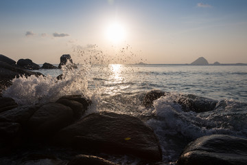 Sea waves lash line impact rock on the beach