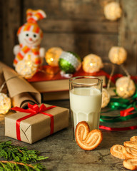 glass of milk and cookies, new year gifts. a cup on the table and a festive atmosphere. top view.