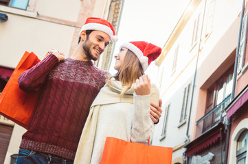 Happy loving couple at Christmas having fun giving gifts