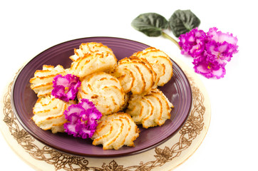 Obraz na płótnie Canvas Violet plate of coconut cookies on wooden background. Close up shot. Macaroons