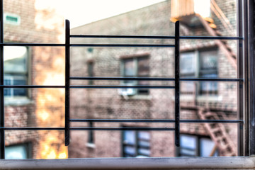 Small apartment window in New York City NYC urban Bronx, Brooklyn brick housing, guard rail, security bars, grunge poor poverty