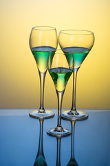 three glasses with cocktails on a blue table 