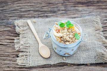 Healthy meal made of granola, yogurt and fruits on a rustic wood background. flat lay, copy space