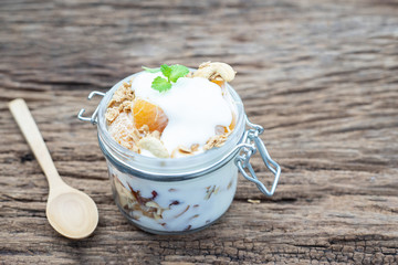 Healthy meal made of granola, yogurt and fruits on a rustic wood background. flat lay, copy space