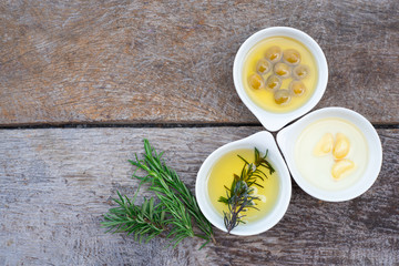 Rosemary,Olive oil with fresh herbs on wooden background copy space .