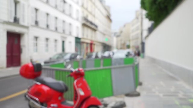 Out of focus view of moped parked in urban setting 