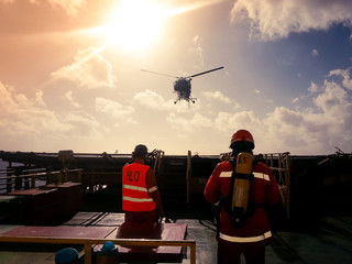 Helicopter landing officer (HLO) and member of a fire team receiving landing helicopter on a offshore drilling rig - 227968218