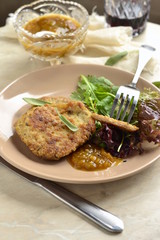 Fried pork chop with fresh herbs and fruit sauce, vertical