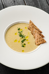 Mushroom cream soup with crackers in a white plate. Concept for a menu in a restaurant