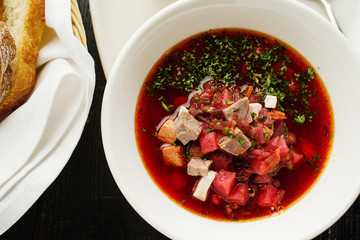 Homemade borsch with meat and sour cream.