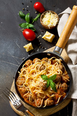 Spaghetti with Meatballs with Tomato Sauce and Parmesan Cheese on a dark stone or concrete background. Copy space.