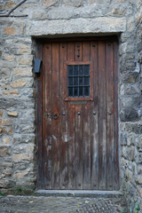 Ancient dark wood entrance door of a stone house