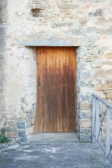 Old dark wood entrance door of a stone house