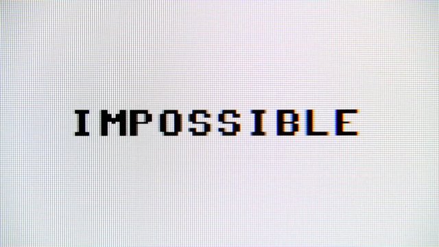 Typing the word Impossible, deleting it and writing Possible instead, on a computer monitor. Macro detail shot.

