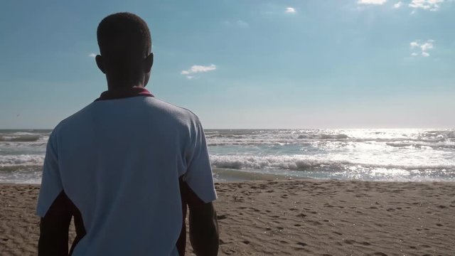 Black man walking towards teh ocean- Hope, nature,joy- slow motion