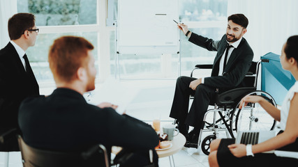 Man in Wheelchair Shows Pointer to White Board.