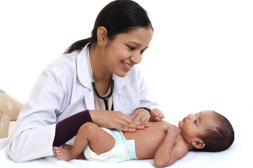 Cheerful female pediatrician holds newborn baby - 227974401